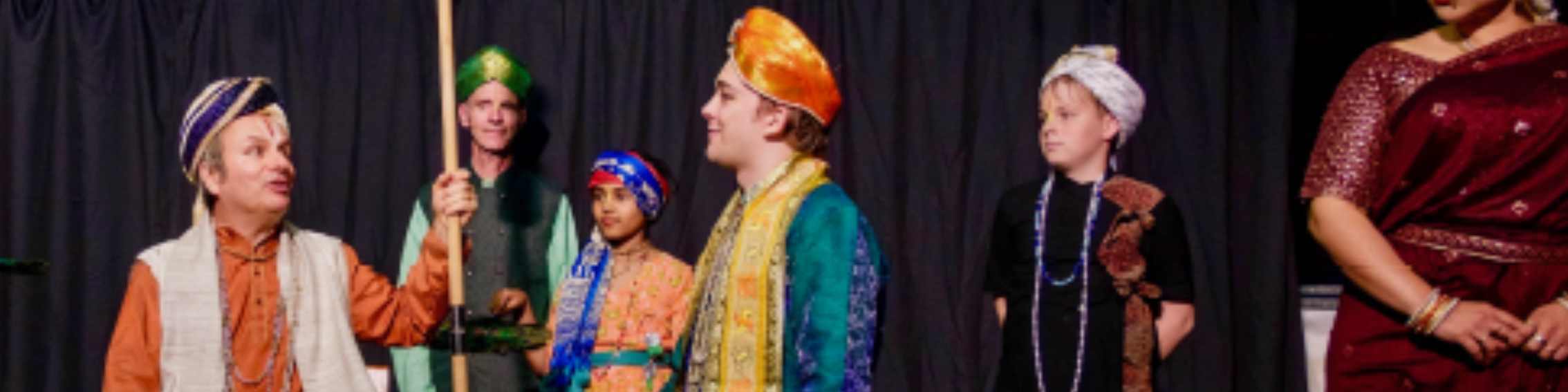 Schauspieler in bunten indischen Gewändern stehen auf einer Bühe