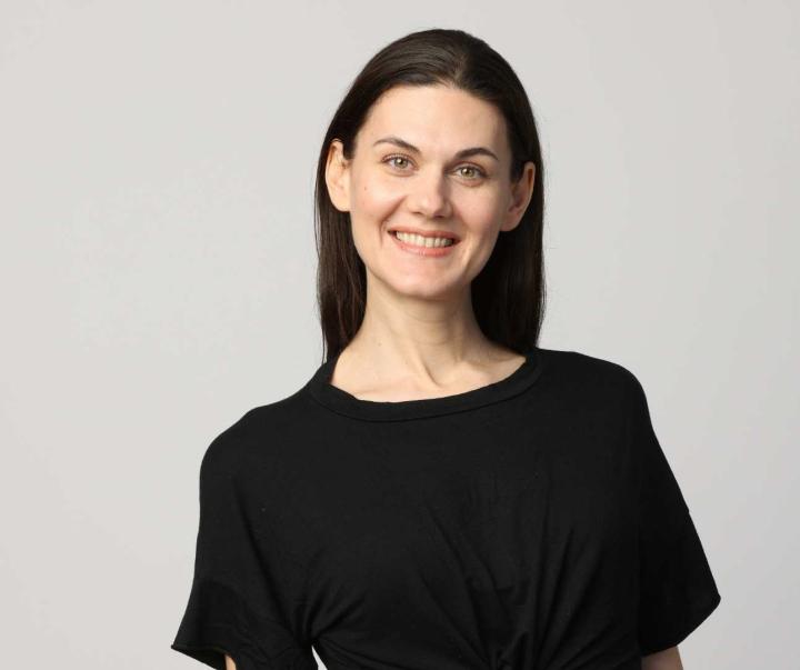 Lächelnde Frau mit langen schwarzen Haaren und schwarzem Shirt