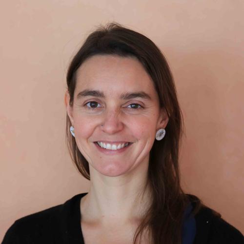 Eine Frau steht neben einem Surfbrett, lächelt freundlich. Eine Frau steht neben einem Surfbrett, lächelt freundlich.