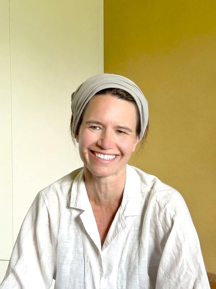 Eine Frau mit Kopfband lächelt